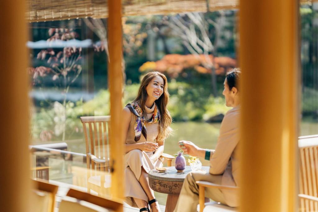 two women sitting at a table on a porch at Four Seasons Hotel Kyoto in Kyoto