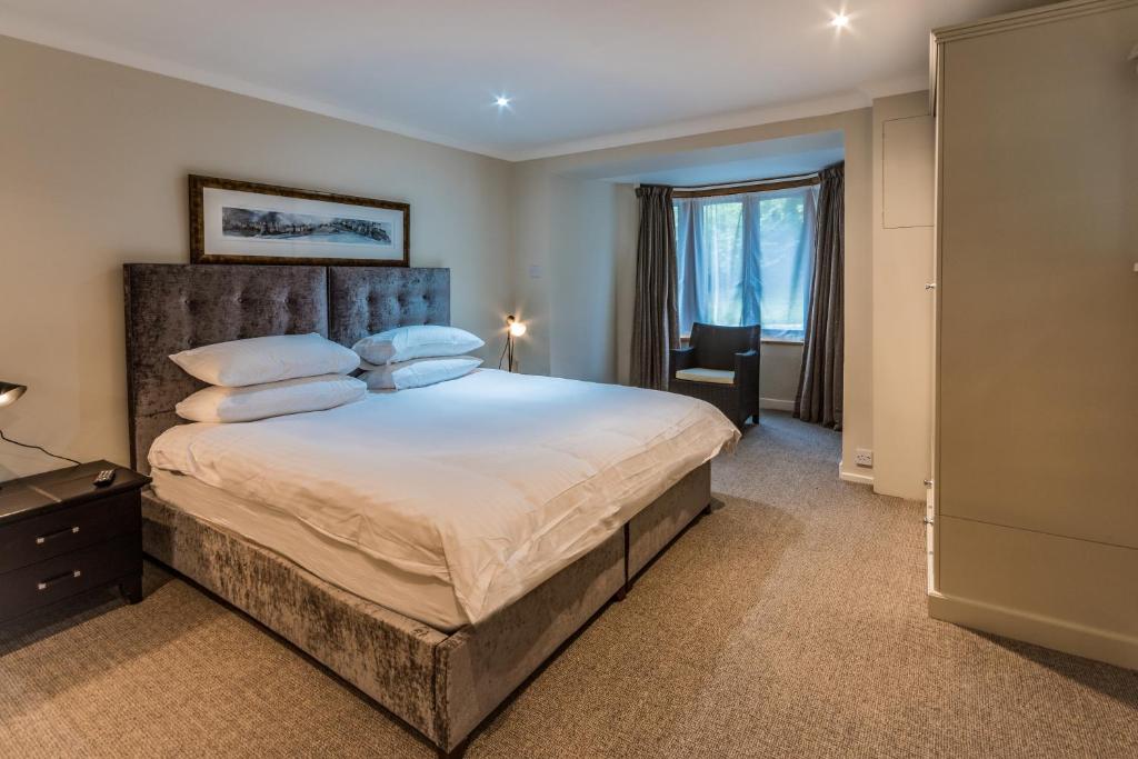 a bedroom with a large bed and a window at LOCH TAY HIGHLAND LODGES and GLAMPING PARK in Morenish