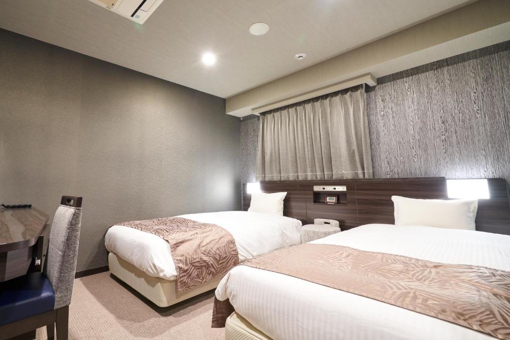 Rúm í herbergi á HOTEL VINE OSAKA KITAHAMA