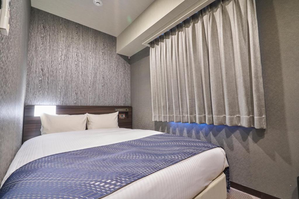 Rúm í herbergi á HOTEL VINE OSAKA KITAHAMA