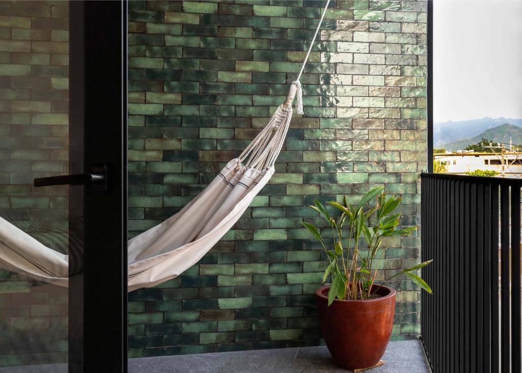 a hammock hanging from a brick wall with a plant at Mako 54 in Puerto Vallarta