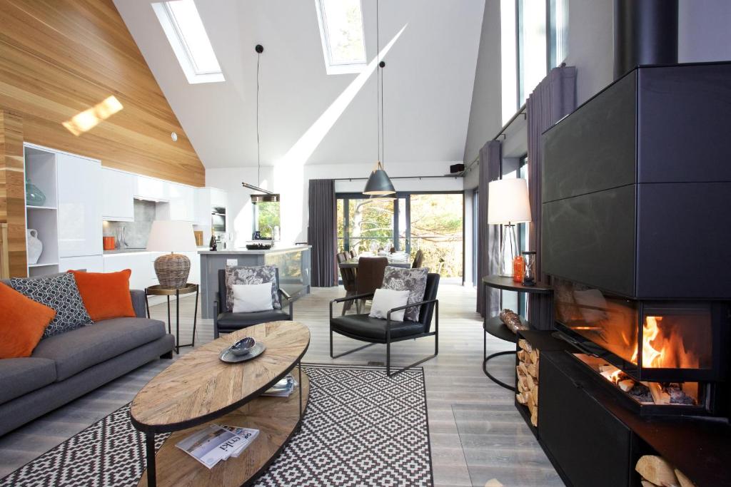 a living room with a fireplace and a couch at LOCH TAY HIGHLAND LODGES and GLAMPING PARK in Morenish