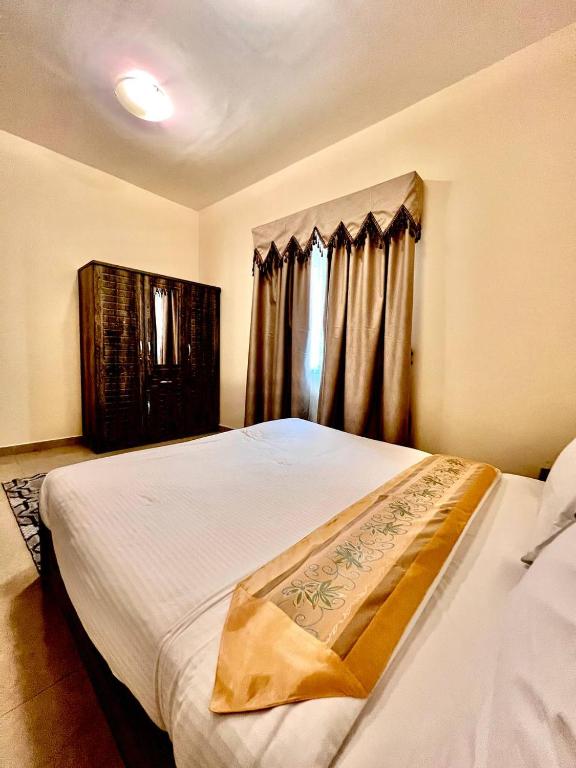 a bedroom with a bed and a window with curtains at Dream Palace Hotel in Ajman 