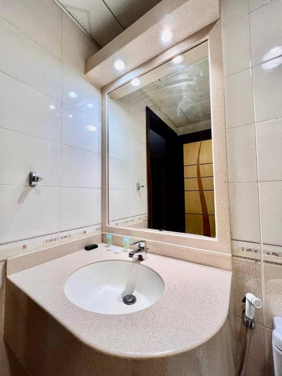 a bathroom with a sink and a mirror at Dream Palace Hotel in Ajman 
