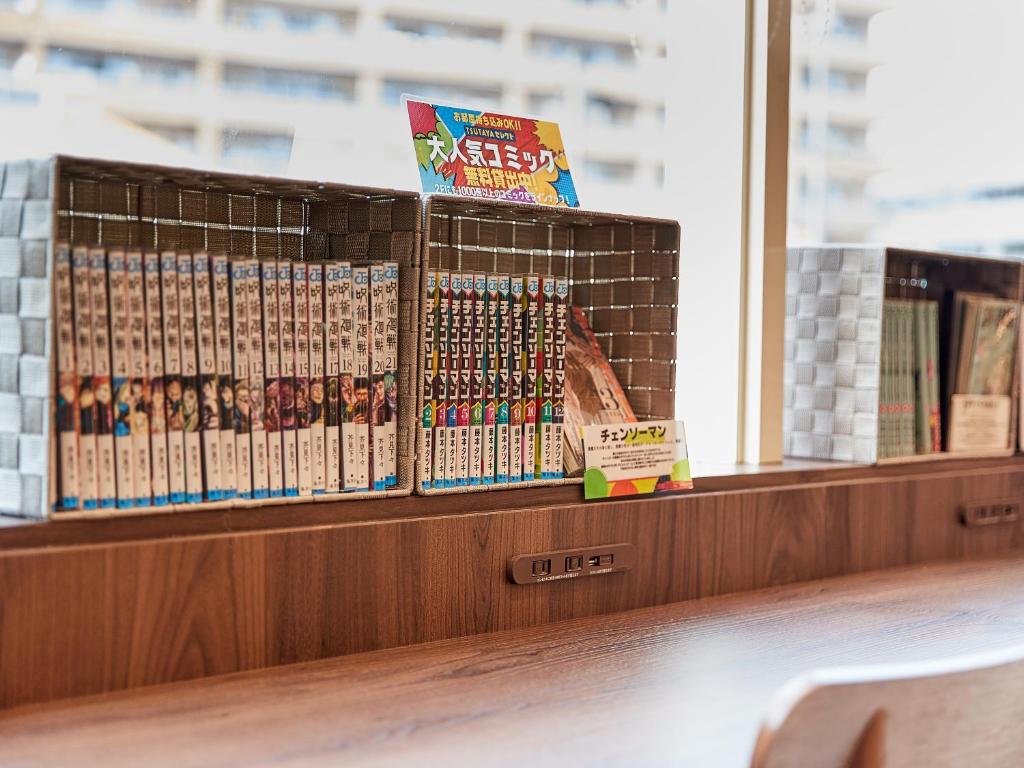 una fila di libri su uno scaffale in una biblioteca di Grand Cabin Hotel Naha Oroku a Naha