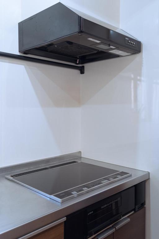 a stove top oven sitting on top of a kitchen counter at 田舎の静かな古民家の悠水居 in Itoman