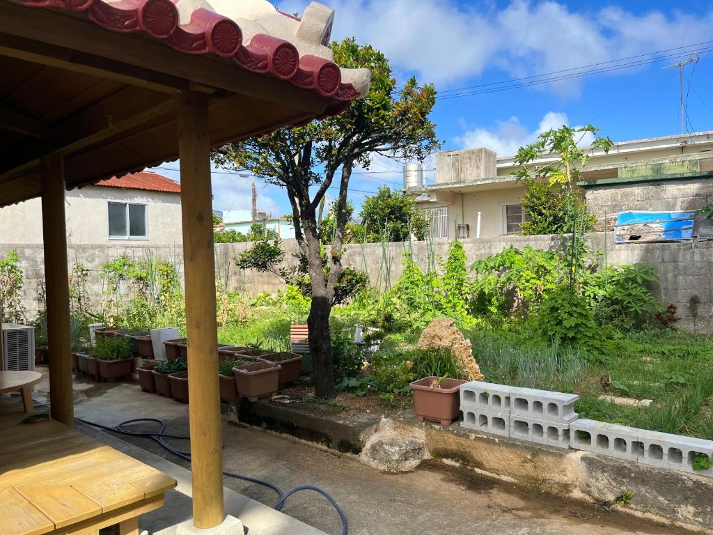 a garden with a fence and a tree in a yard at 田舎の静かな古民家の悠水居 in Itoman