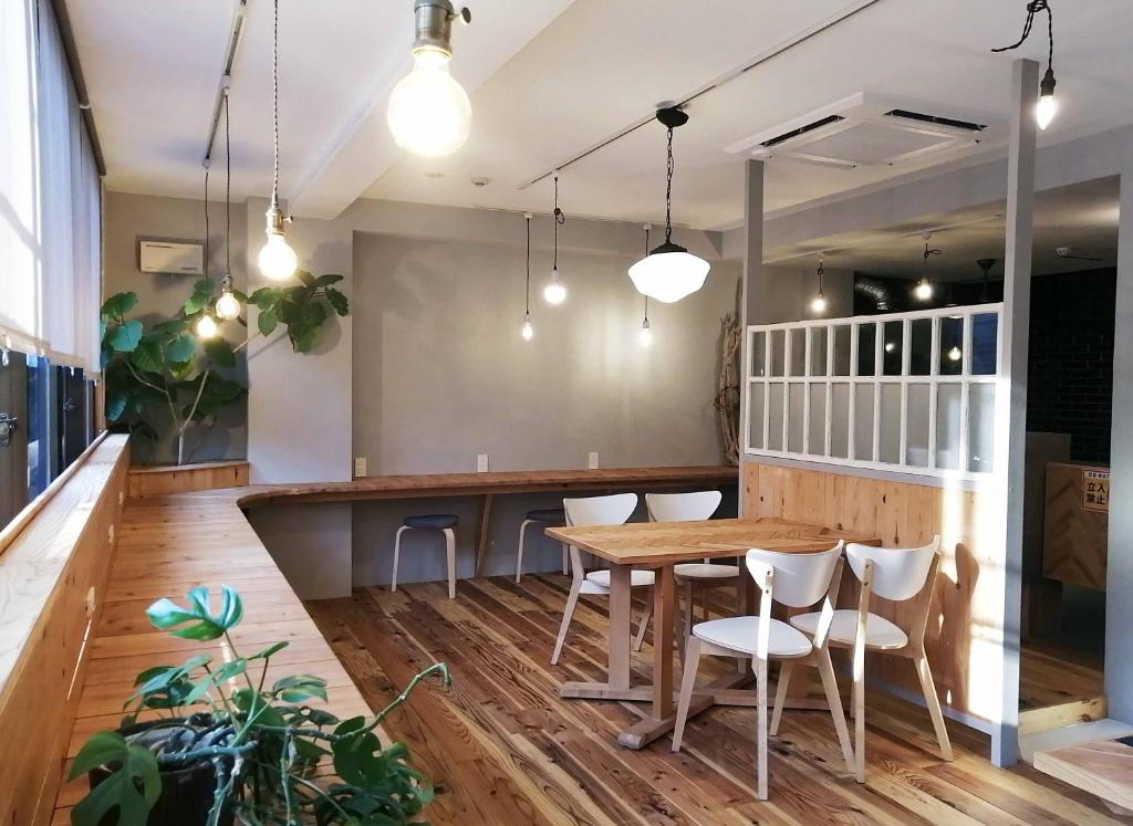 a dining room with a wooden table and chairs at Ten to Sen Guesthouse in Takamatsu
