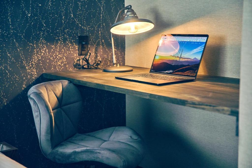 a laptop computer sitting on a wooden desk with a chair at ルクス箱根湯本 LUX HAKONE YUMOTO in Hakone