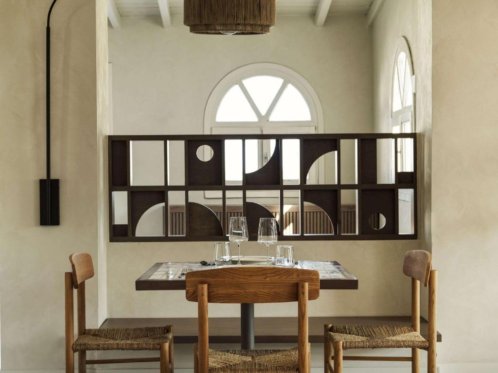 a dining room with a table and two chairs at Lindian Village All Inclusive Resort Rhodes,Curio Collection in Kiotari