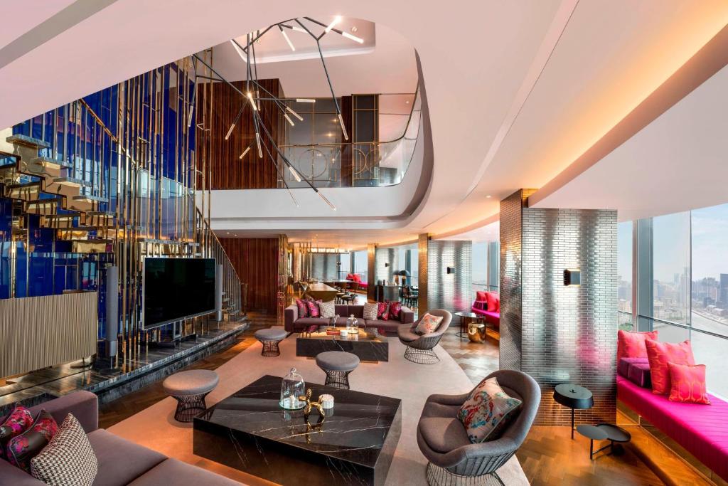 a living room with couches and a tv at W Shanghai - The Bund in Shanghai