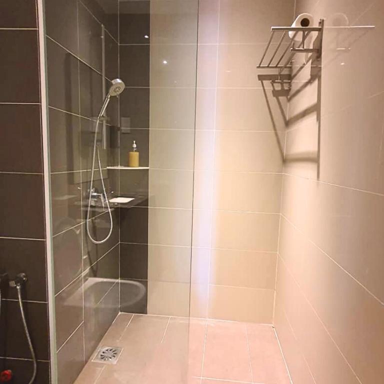 a shower with a glass door in a bathroom at family 1 bed room apartment in Melaka