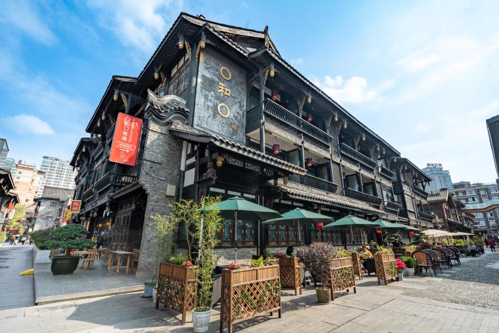 een gebouw met tafels en parasols in een straat bij Buddha Zen Hotel in Chengdu
