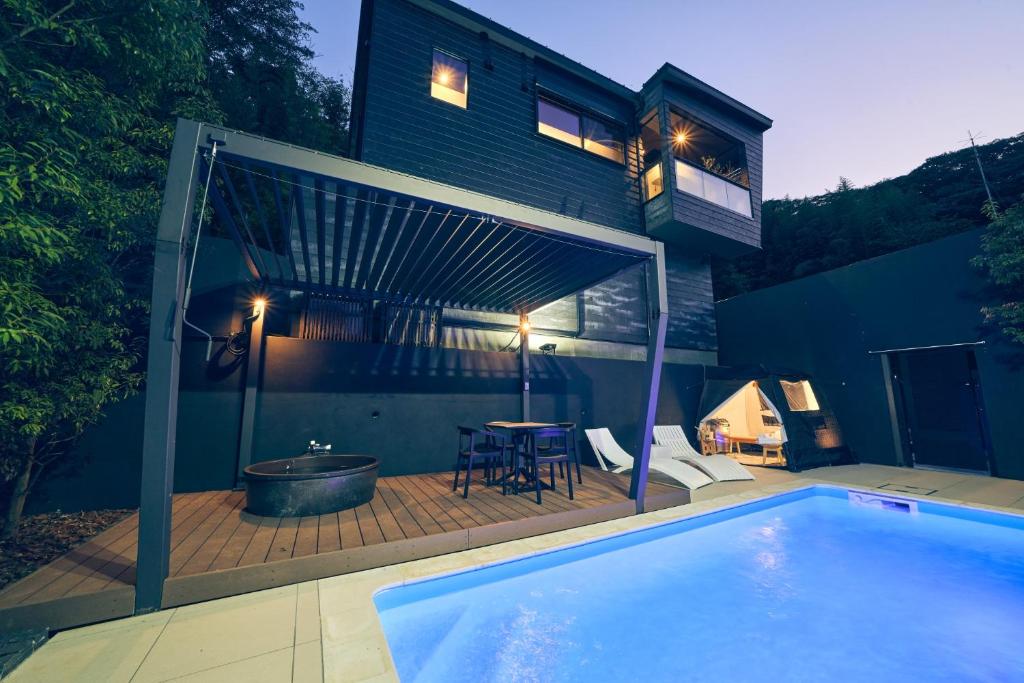 a house with a swimming pool in front of it at ルクス箱根湯本 LUX HAKONE YUMOTO in Hakone