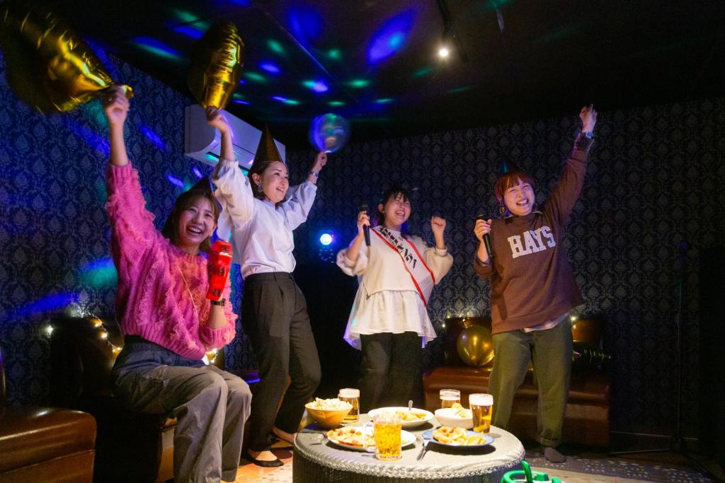 a group of children standing in a room with their hands in the air at 炉之宿 淀川 in Osaka