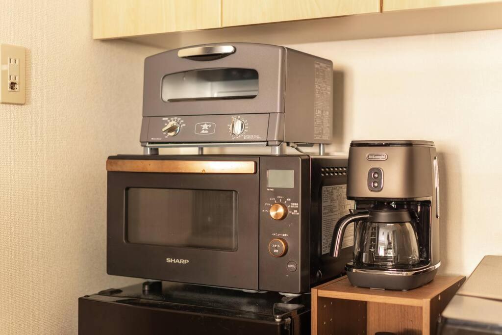 a microwave and coffee maker sitting on top of a coffee machine at Cozy Stay Sapporo Central 301 in Toyohira