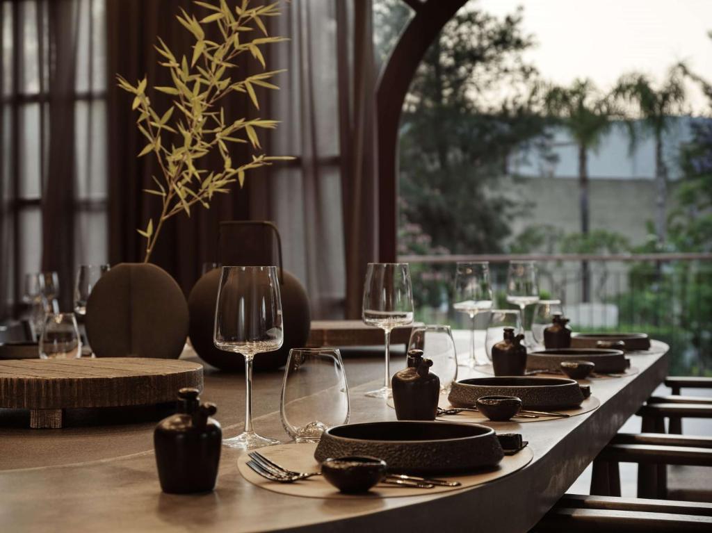 a table with plates and wine glasses on it at Lindian Village All Inclusive Resort Rhodes,Curio Collection in Kiotari