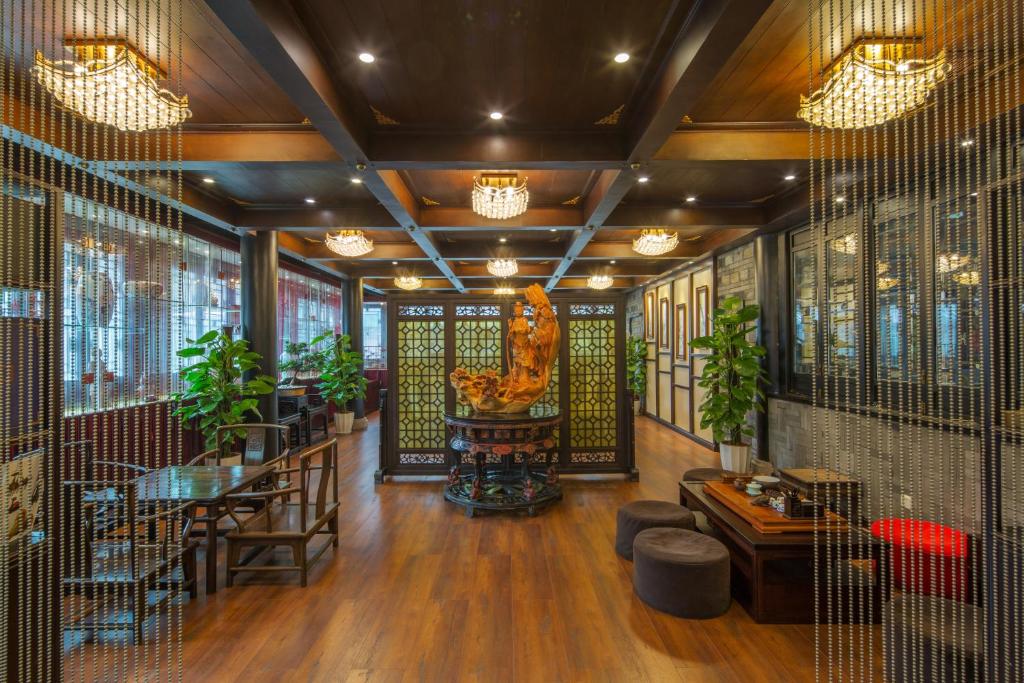 een restaurant met een tafel, stoelen en planten bij Buddha Zen Hotel in Chengdu