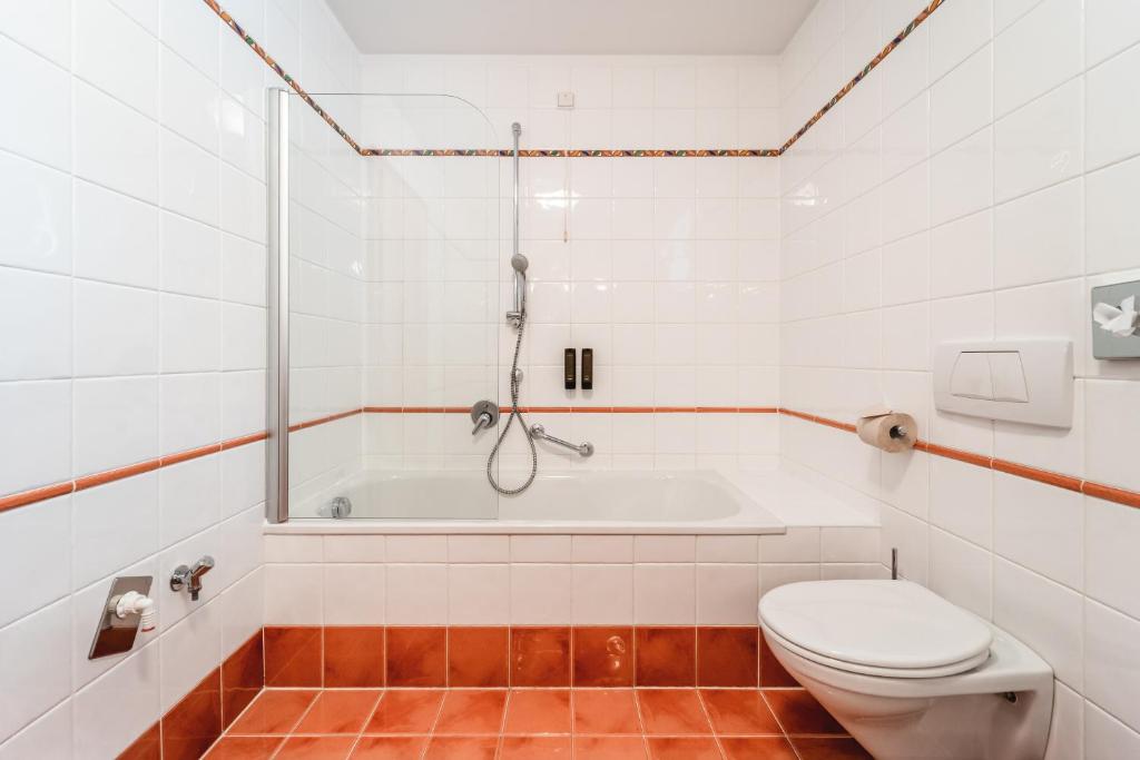 a bathroom with a toilet and a bath tub at Naturhotel Leitlhof in San Candido