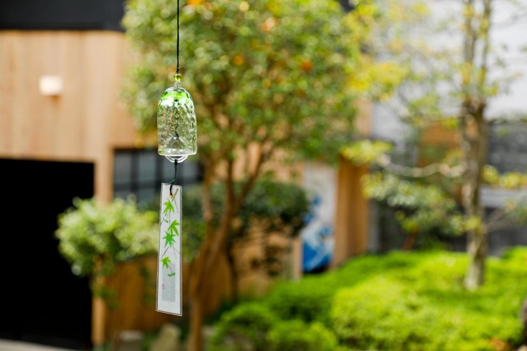 a bird feeder hanging from a tree in a yard at 炉之宿 淀川 in Osaka