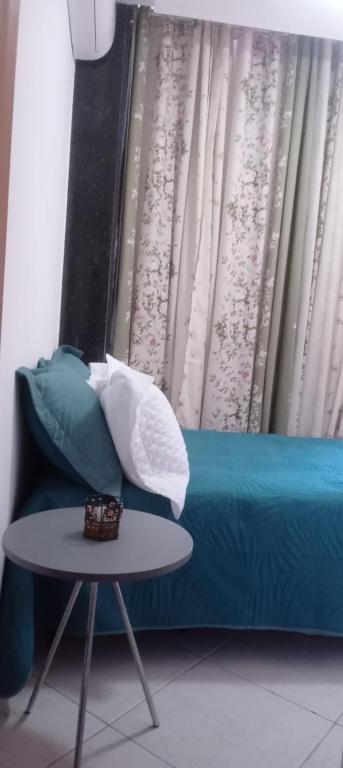 a blue couch with pillows and a table in a room at Quarto plutão in Duque de Caxias