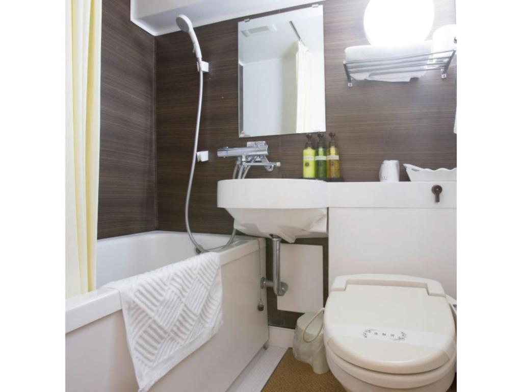 a bathroom with a sink and a toilet and a tub at Hotel Tetora Tsurumi - Vacation STAY 37279v in Yokohama