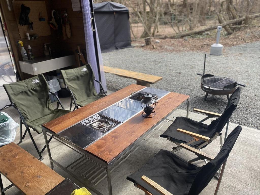 a wooden table and two chairs and a table and a grill at SNUG CAMP HOUSE - Vacation STAY 98115v in Okubo