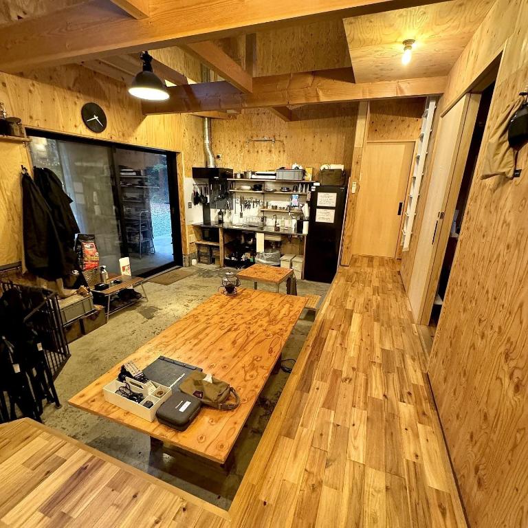 a large room with a wooden table and a kitchen at SNUG CAMP HOUSE - Vacation STAY 98114v in Okubo