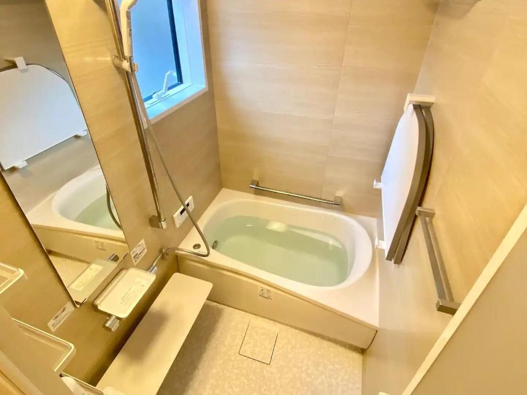 a small bathroom with a tub and a mirror at SNUG CAMP HOUSE - Vacation STAY 98114v in Okubo