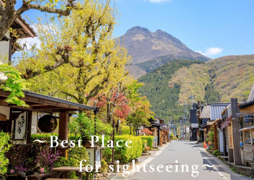 a street in a town with mountains in the background at Resort Stay Spa Tsurumi in Beppu