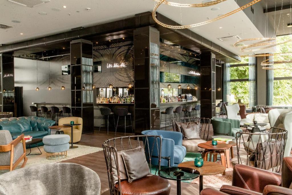 a lobby of a hotel with chairs and a bar at Motel One Berlin-Hauptbahnhof in Berlin