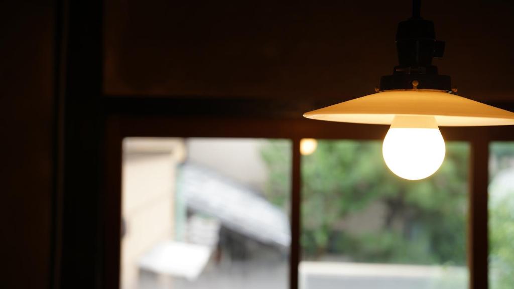 a light bulb hanging from a window at Kaikoan in Kyoto