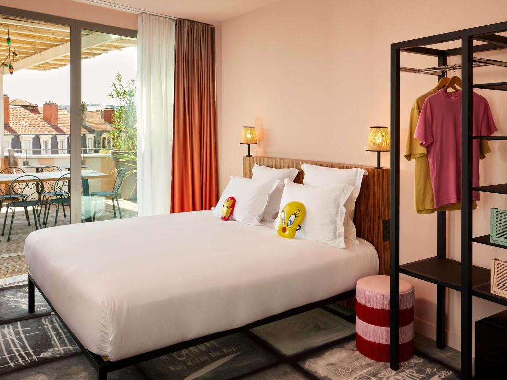 a bedroom with a bed with two stuffed animals on it at Mama Shelter Lyon in Lyon