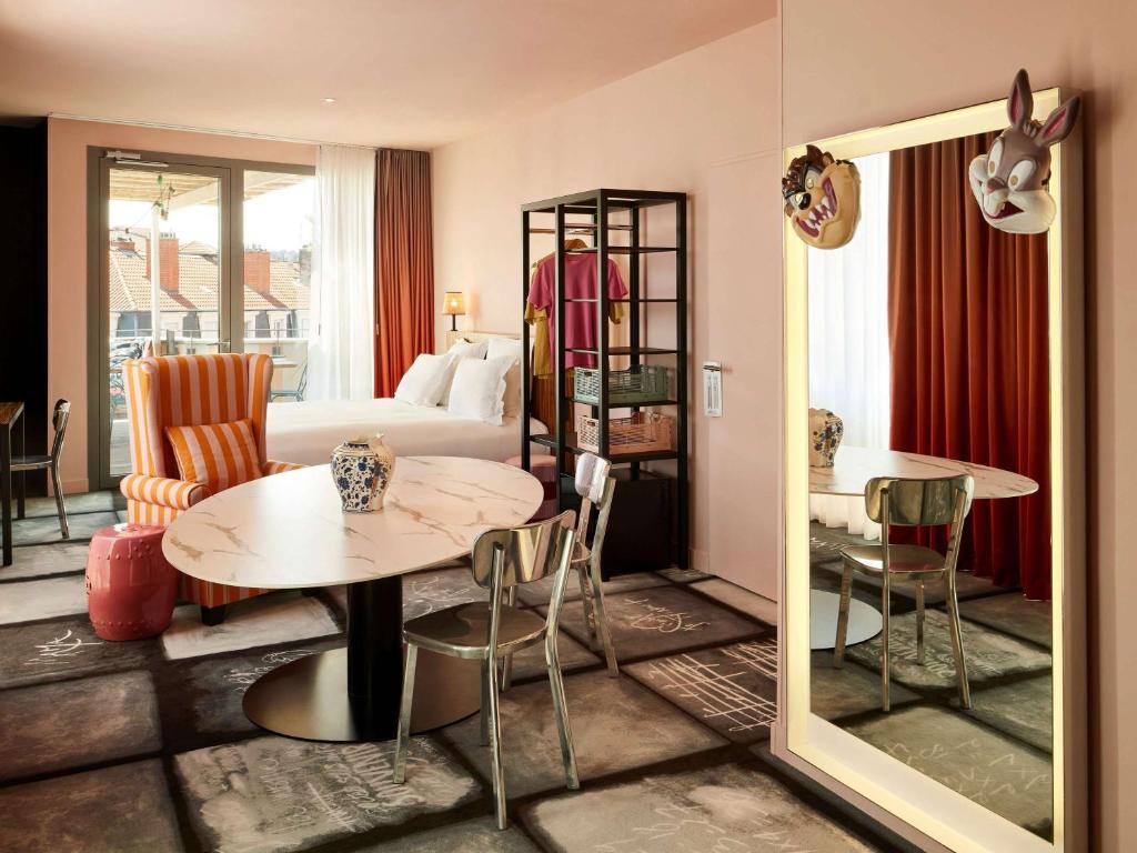 a hotel room with a bed and a table and chairs at Mama Shelter Lyon in Lyon