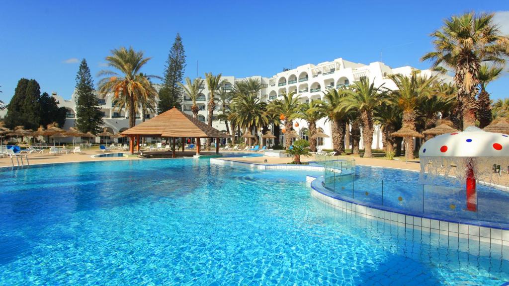 duży basen w ośrodku z palmami w obiekcie Hotel Marhaba Beach w Susie
