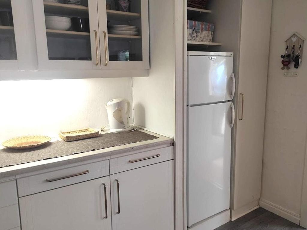 a kitchen with white cabinets and a white refrigerator at Holiday home BORÅS II in Borås