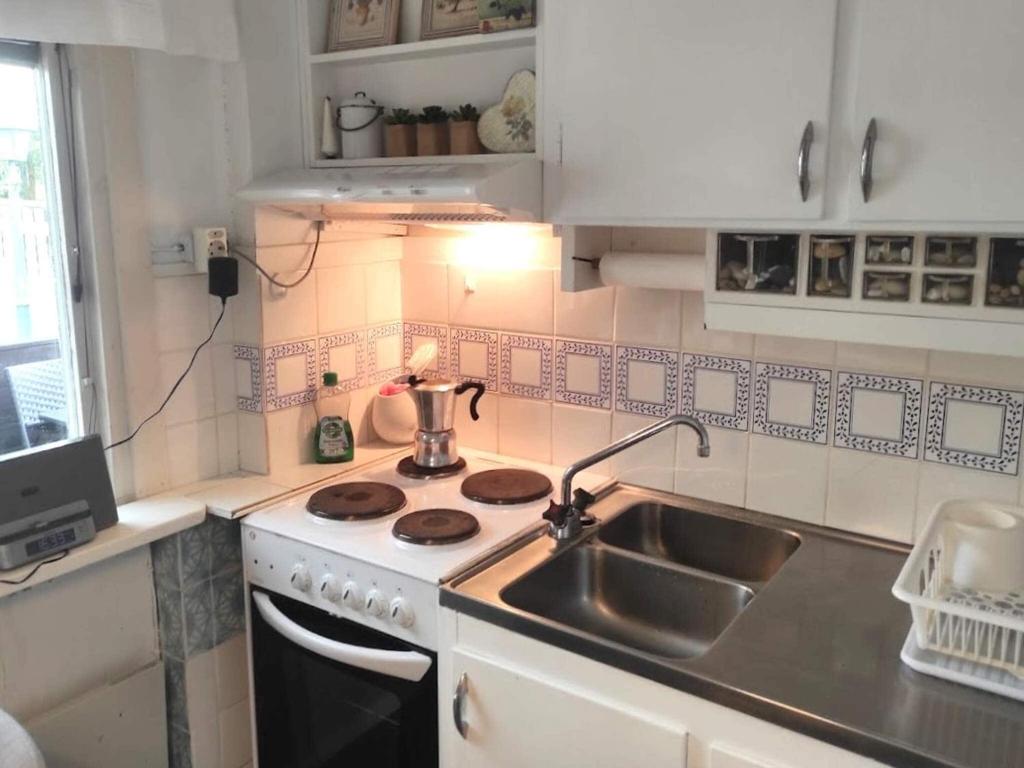 a small kitchen with a stove and a sink at Holiday home BORÅS II in Borås