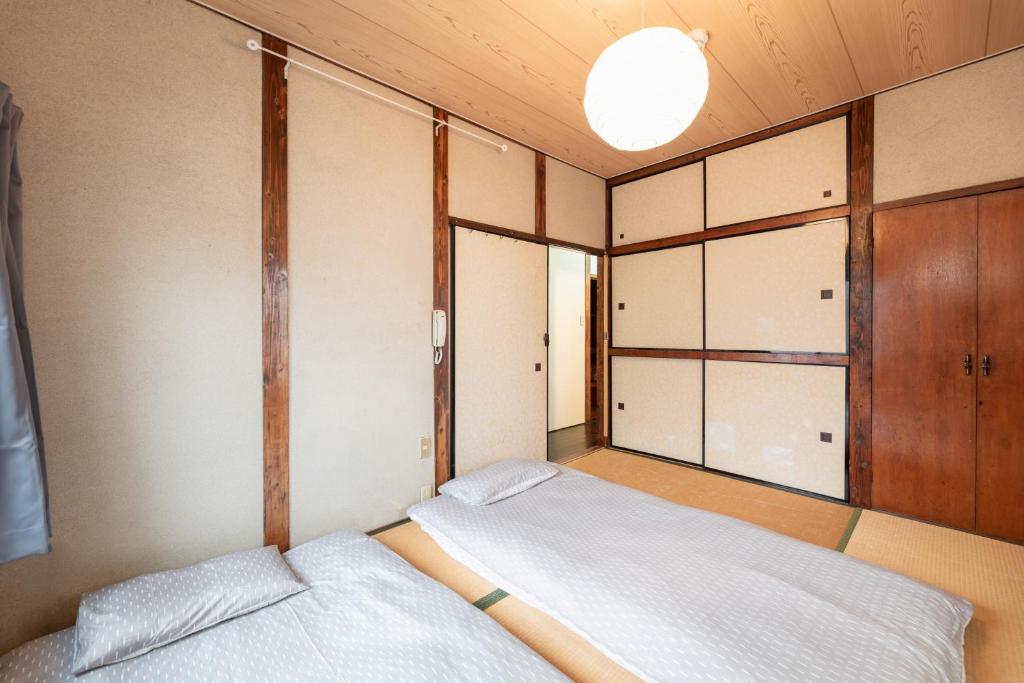 a small bedroom with two beds and a window at Osaka Kanzakigawa Royal駅徒步1分 "private house 3 bed rooms "一棟貸し宿 in Osaka
