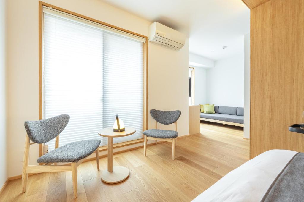 a bedroom with two chairs and a window at Dash Living Gojo in Kyoto
