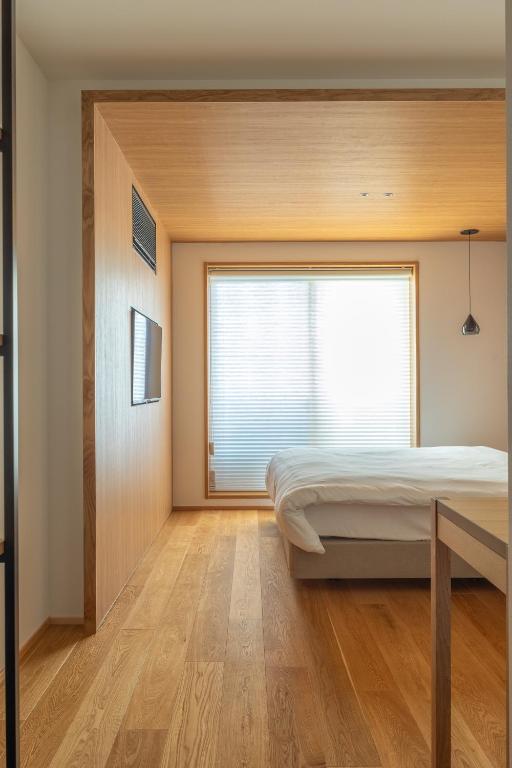 a bedroom with a bed and a window at Dash Living Gojo in Kyoto