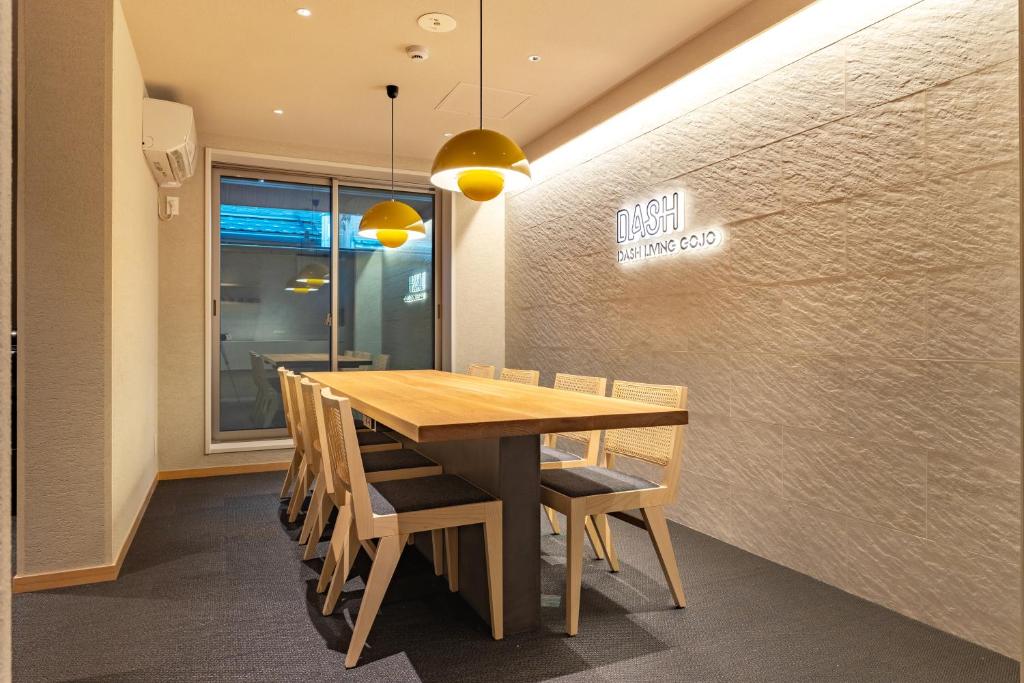 a dining room with a wooden table and chairs at Dash Living Gojo in Kyoto