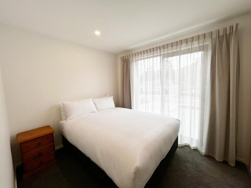 Swiss-Belresort and Villas Coronet Peak tesisinde bir odada yatak veya yataklar