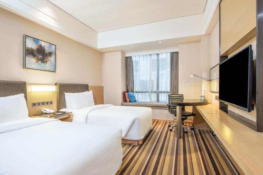 a hotel room with two beds and a flat screen tv at Holiday Inn Express Shenyang Golden Corridor by IHG in Shenyang