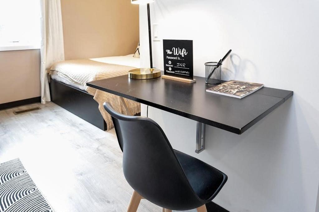 a black desk with a chair in a room at Comfy Studio with Kitchen Central Danbury ADA in Danbury