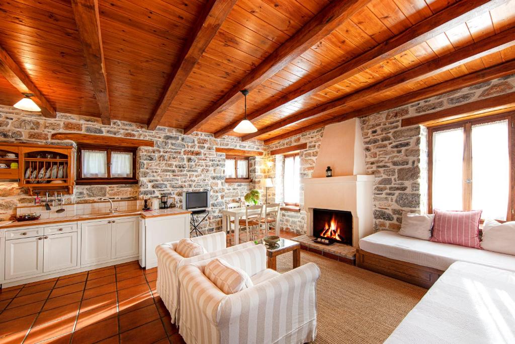 cocina y sala de estar con pared de piedra en Amanita boutique hotel, en Tsagkarada
