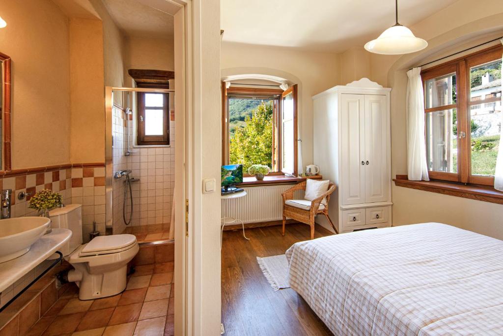y baño con cama, lavabo y aseo. en Amanita boutique hotel, en Tsagkarada