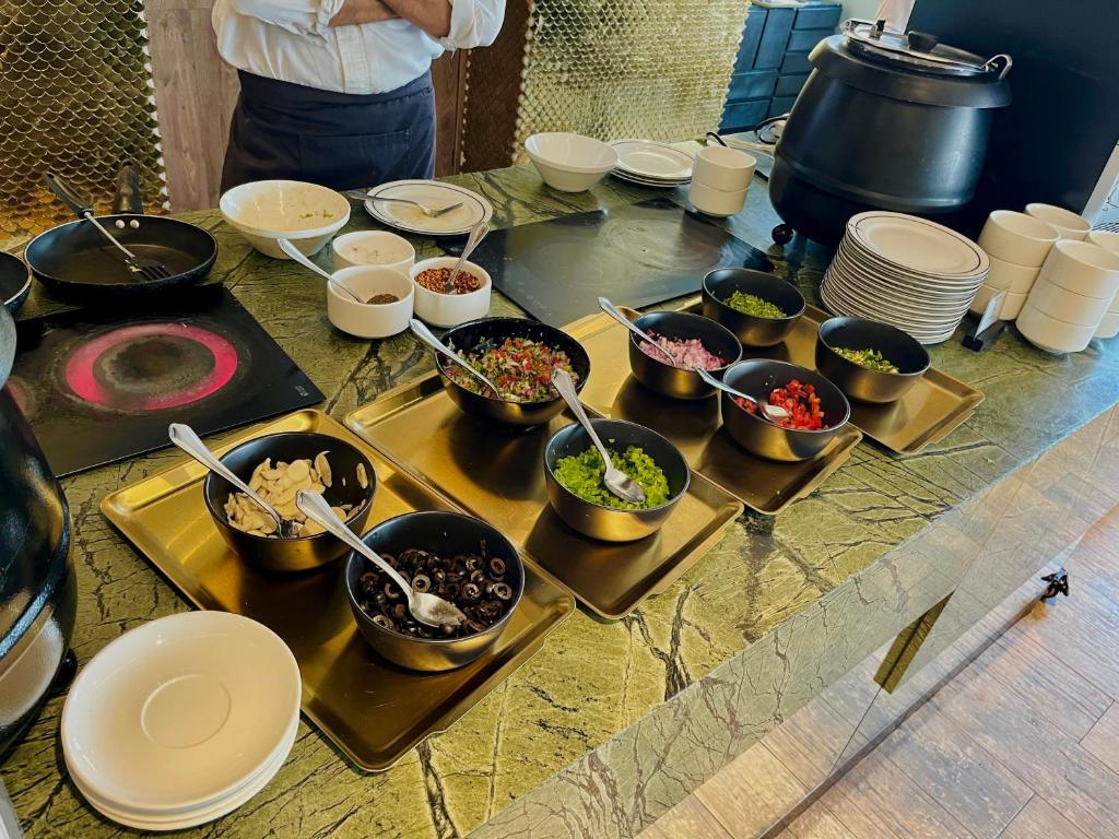 a table with many bowls of food on it at The Nishat Hotel Johar Town in Lahore