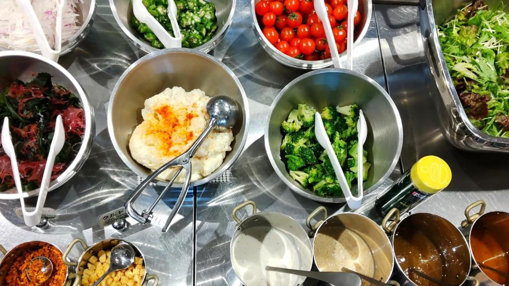 a buffet filled with bowls of different types of food at Almont Hotel Nippori in Tokyo