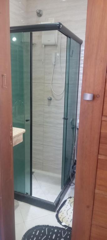 a shower with a glass door in a bathroom at Quarto plutão in Duque de Caxias