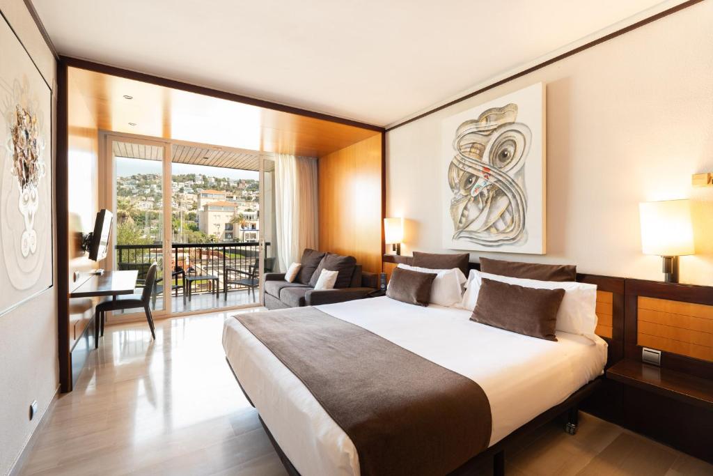 a bedroom with a large bed and a living room at Estela Barcelona in Sitges